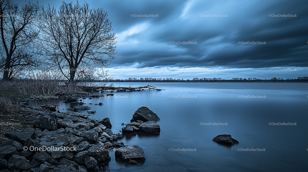 Dramatic Twilight over Tranquil Lake with Rocky Shoreline
