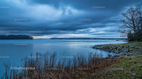 Stormy Sky Over Tranquil Lake with Natural Shoreline
