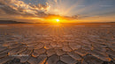 Sunset Over Cracked Desert Landscape with Glowing Sky