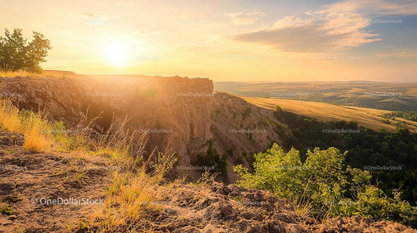 Scenic Sunset Over Rocky Cliff and Rolling Hills
