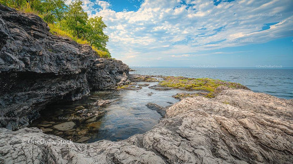 Rocky Shoreline with Blue Sky and Calm Sea