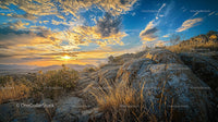 Sunset Over Rocky Terrain with Dramatic Skies