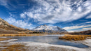 Snowy Mountains and Frozen Lake Under Blue Sky