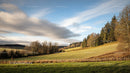 Rolling Hills and Scenic Landscape under Cloudy Blue Sky
