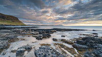 Dramatic Coastal Sunset Over Rocky Shoreline