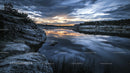 Tranquil Sunset Over Reflective Lake with Rocky Shoreline