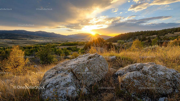 Breathtaking Sunset Over a Mountain Valley with Rocks in Foreground