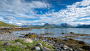 Majestic Mountain Range and Serene Rocky Shoreline Vista