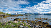 Majestic Mountain Range and Serene Rocky Shoreline Vista
