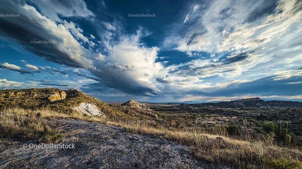 Dramatic Clouds Over Rocky Desert Landscape