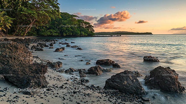 Tropical Island Shoreline at Sunset with Rocky Beach