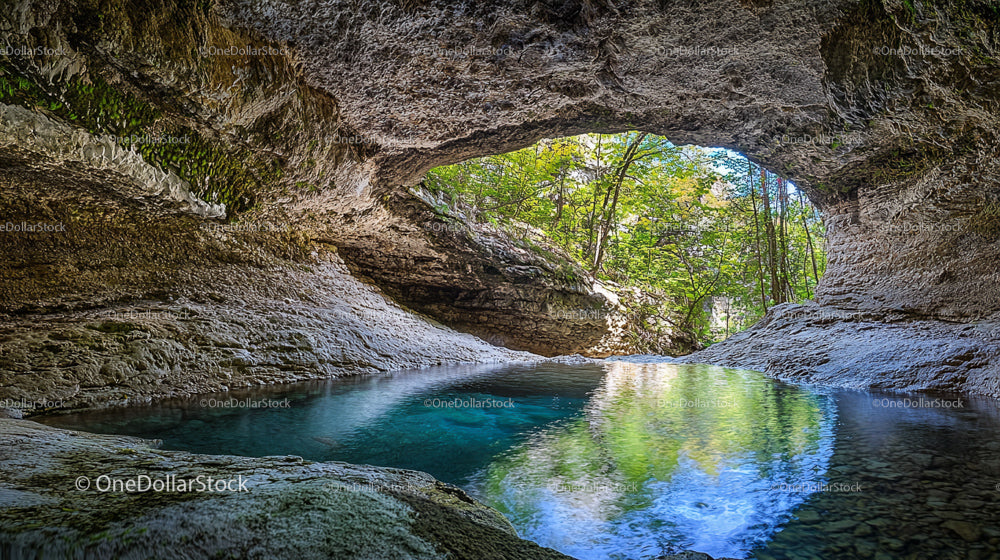 Serene Cave Retreat with Crystal Clear Waters and Lush Greenery