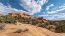 Scenic Red Rock Formation under Blue Sky with Fluffy Clouds