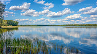 Tranquil Lake with Reflective Sky and Green Horizon
