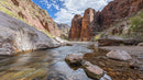 Rocky Canyon with Flowing River Under Blue Sky