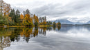 Serene Lake with Autumn Foliage and Misty Mountains