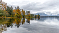 Serene Lake with Autumn Foliage and Misty Mountains
