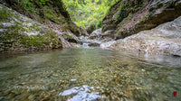 Crystal Clear Stream Flowing Through Rocky Landscape