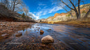 Tranquil River Landscape with Rocky Shoreline and Blue Sky