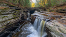 Scenic Waterfall Under Stone Bridge in Autumn Forest