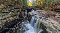 Scenic Waterfall Under Stone Bridge in Autumn Forest