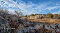 Rocky Desert Landscape with Blue Skies and Sparse Vegetation