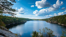 Tranquil Lake Surrounded by Forest Under Blue Sky