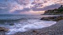Peaceful Coastal Sunset with Waves and Rocky Shoreline