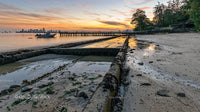 Sunset Over Urban Skyline with Tranquil Beach Shoreline