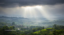 Sun Rays Breaking Through Clouds Over Lush Green Hills