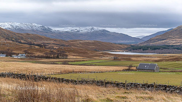 Stone Cottage Amidst Rolling Hills and Snow-Capped Mountains