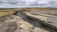 Eroded Rocky Landscape Under Dramatic Overcast Sky