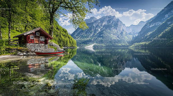 Serene Alpine Lake with Red Cabin and Mountain Views