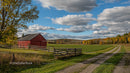 Red Barn in Vibrant Autumn Countryside with Cloudy Sky