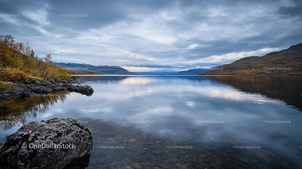 Tranquil Lake with Autumn Trees and Rocky Shores