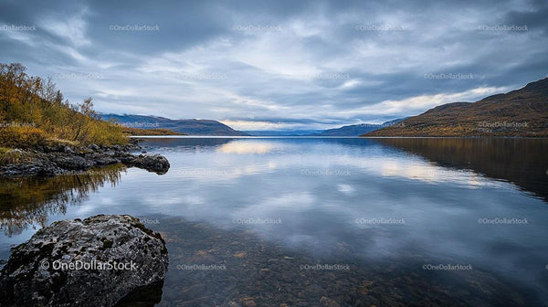 Tranquil Lake with Autumn Trees and Rocky Shores