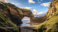 Sunlit Natural Arch with Rocky Cliffs and Blue Ocean View
