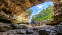 Scenic Sandstone Cave Overlooking Lush Forest and Blue Sky