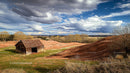 Rustic Barn and Rolling Hills Under Dramatic Clouds