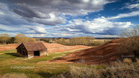 Rustic Barn and Rolling Hills Under Dramatic Clouds