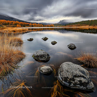 Tranquil Autumn Lake with Rocks and Reflective Waters