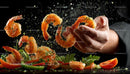 Chef Tossing Seasoned Shrimp with Fresh Herbs and Spices