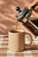 Pouring Fresh Coffee from French Press into Ceramic Mug