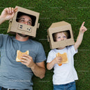 Father and Son Playing with Cardboard Helmets on Grass
