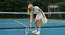 Young Woman Picking Up Tennis Ball on Court