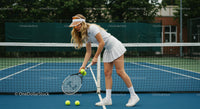 Female Tennis Player in White Preparing on Blue Court