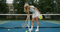 Female Tennis Player Setting Up for Practice on Outdoor Court