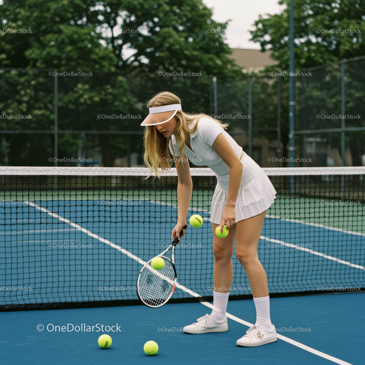 Female Tennis Player on Blue Court with Tennis Balls