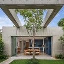 Modern Concrete Structure with Outdoor Dining and Tree Canopy