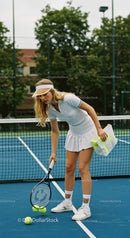 Young Tennis Player in White Attire on Court